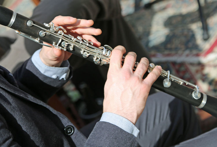 Midsection of man playing flute 