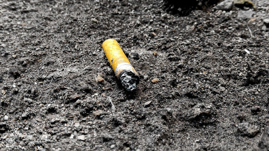 High angle view of cigarette smoking on ground