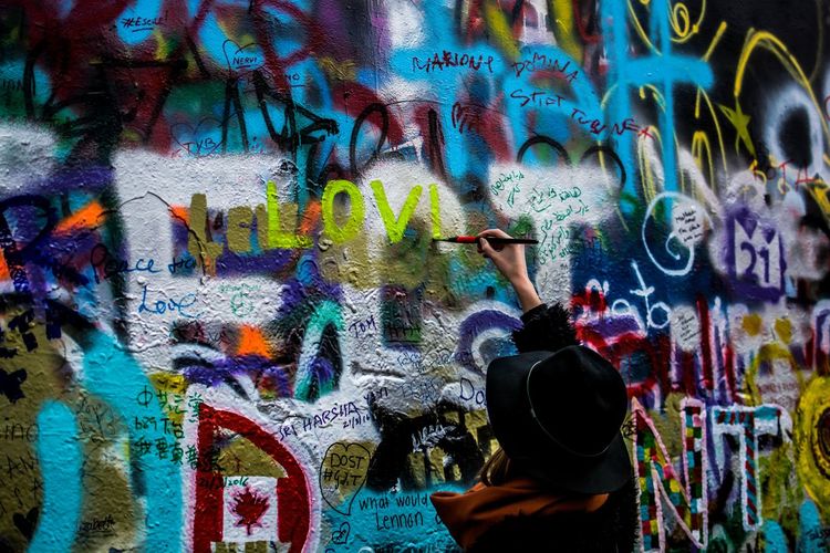 Rear view of person painting on john lennon wall