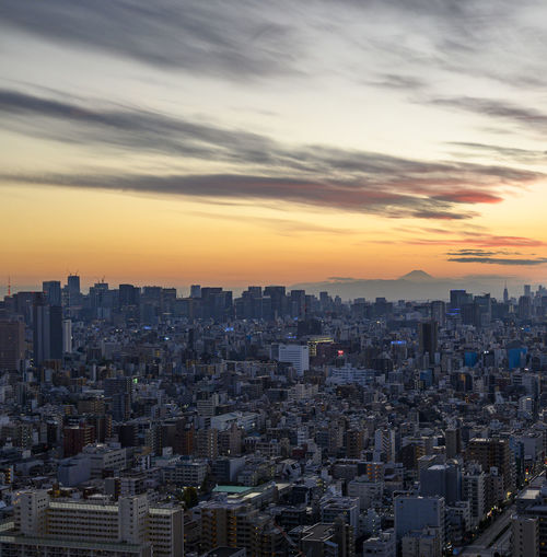 Aerial view of cityscape against sky during sunset
