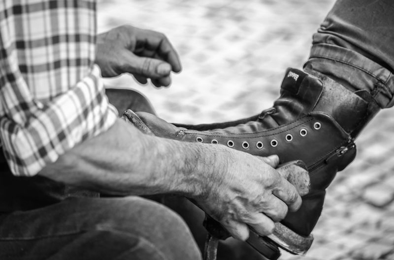 Midsection of man polishing shoe