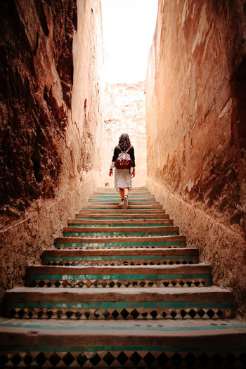 Rear view of woman climbing stairs