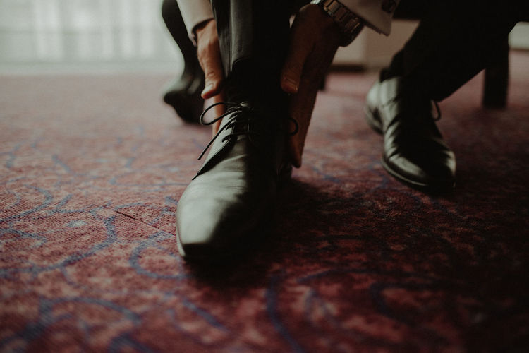Low section of man wearing shoes at home