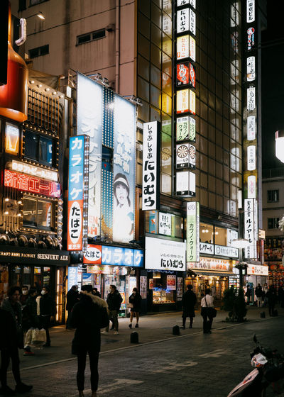 People walking on street in city at night