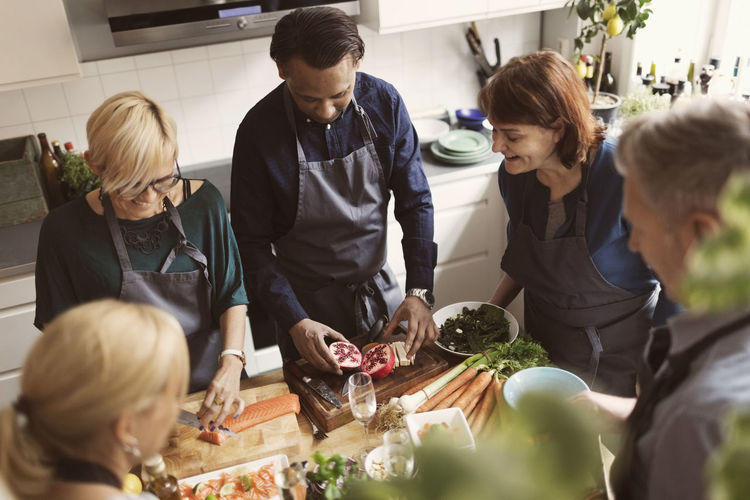High angle view of multi-ethnic friends preparing food in kitchen