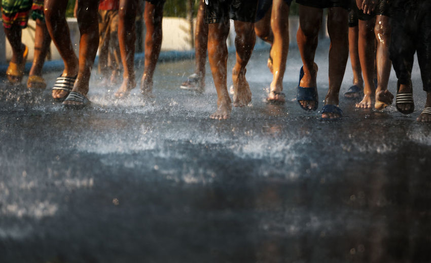 Low section of people running on wet street