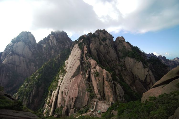 Scenic view of mountains against cloudy sky
