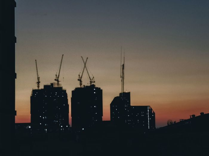 Silhouette buildings against sky at dusk