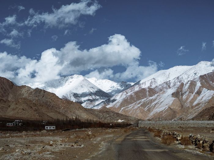 Road amidst snowcapped mountains against sky