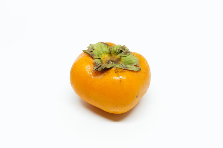 High angle view of orange fruit against white background