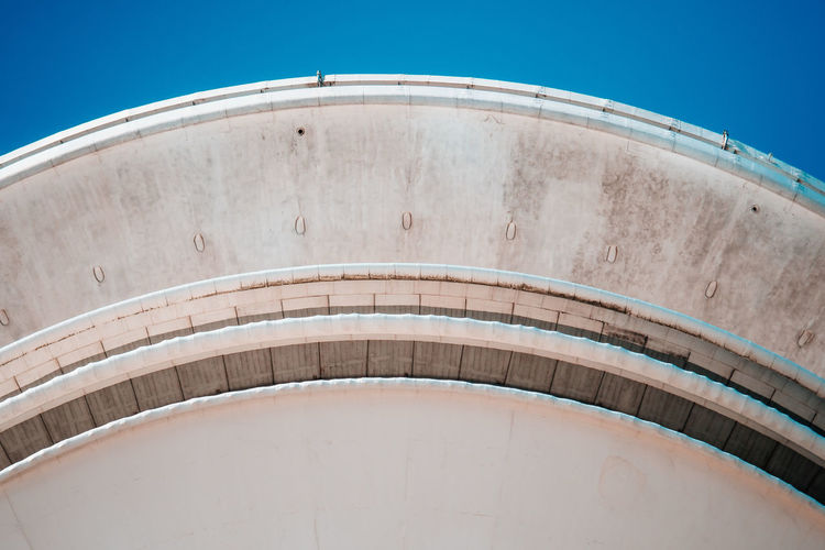 Low angle view of storage tank against blue sky