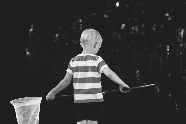 Rear view of boy holding umbrella