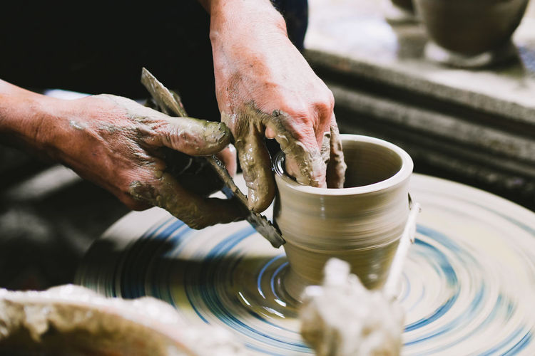 Cropped hands of man making pot in workshop