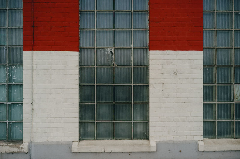 Brick and glass wall with red and white pattern.