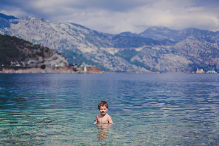 Little smiling boy in the sea.