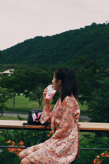Woman photographing while looking at camera