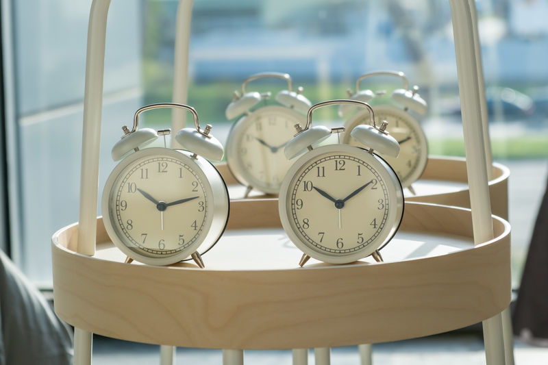 Retro styled alarm clocks on round shelf with shallow focus