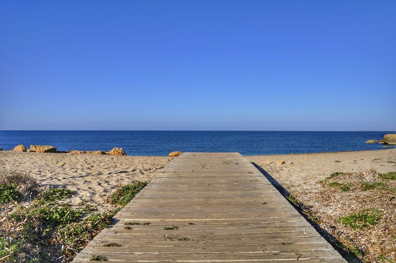 Scenic view of sea against clear blue sky
