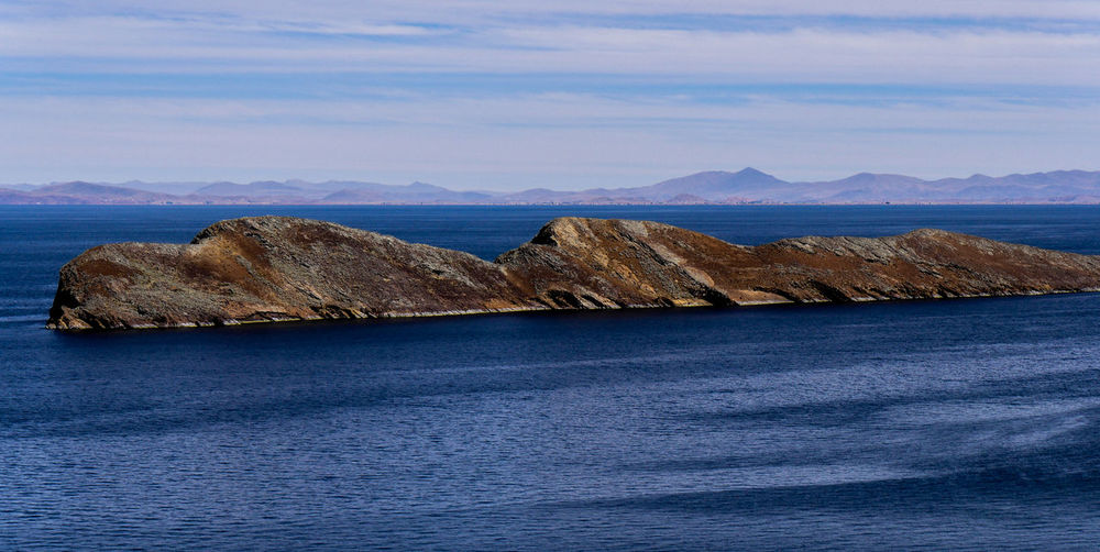 Scenic view of island on lake titicaca against sky