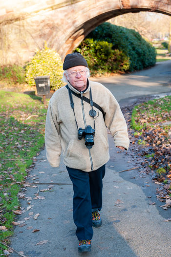 Full length portrait of man standing on footpath