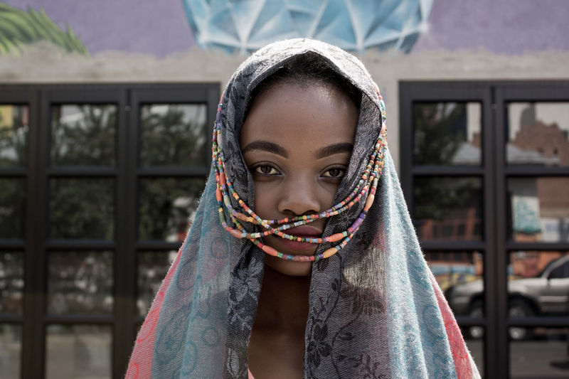 Close-up portrait of young woman wearing headscarf with beads