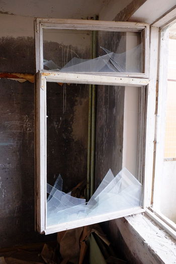 Broken glass window of abandoned house