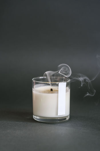 A smoking handmade candle on a dark background.