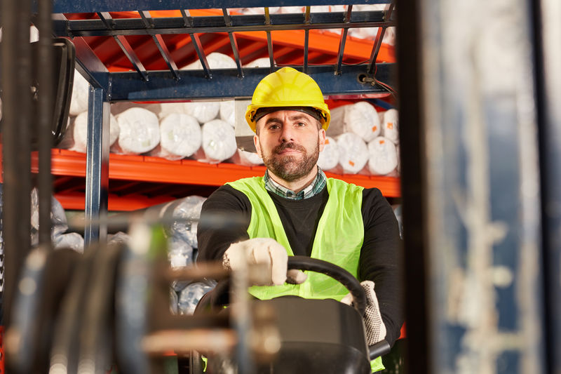 Portrait of foreman driving forklift at factory