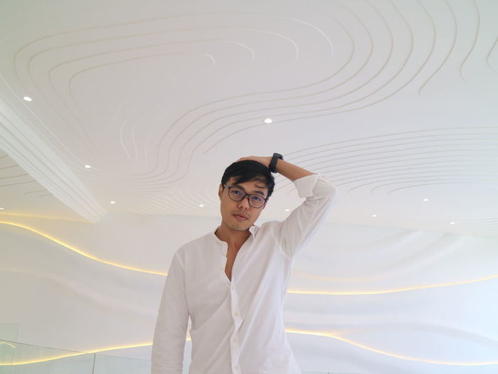 Portrait of a smiling young man standing in leaving room