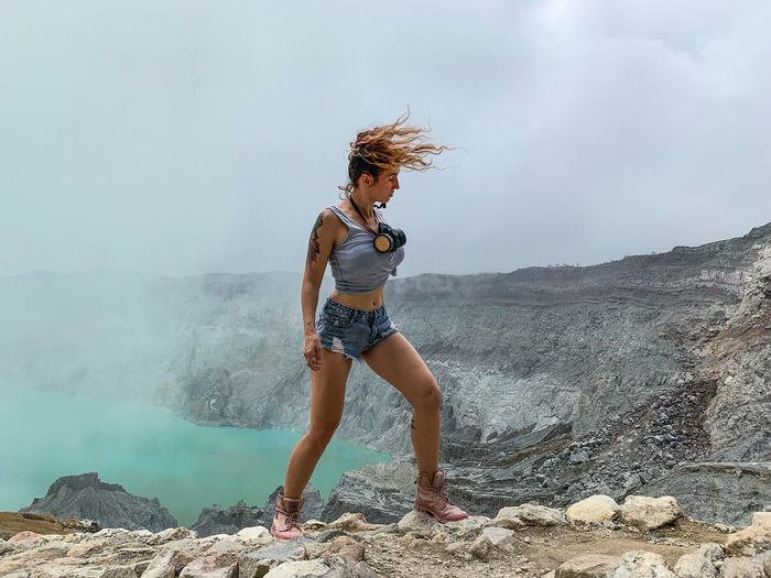 Full length of woman standing by volcanic crater