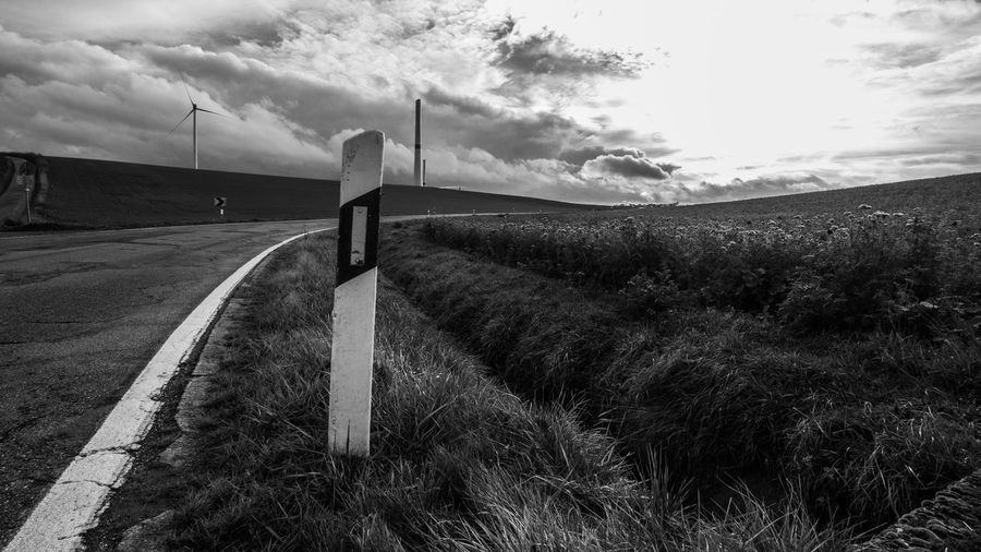 Road amidst field against sky