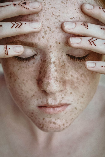 Close-up portrait of a girl with freckles and closed eyes