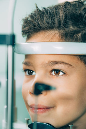 Close-up of boy with eye test equipment