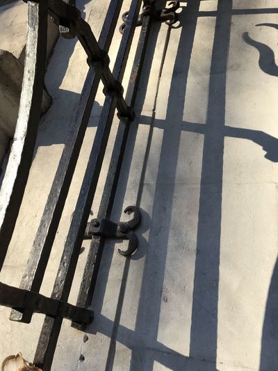 High angle view of metal gate on sunny day