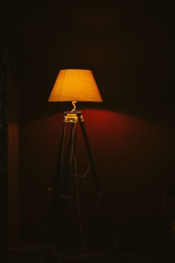 Close-up of electric lamp against wall at night