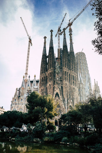 Low angle view of sagrada familia against cloudy sky