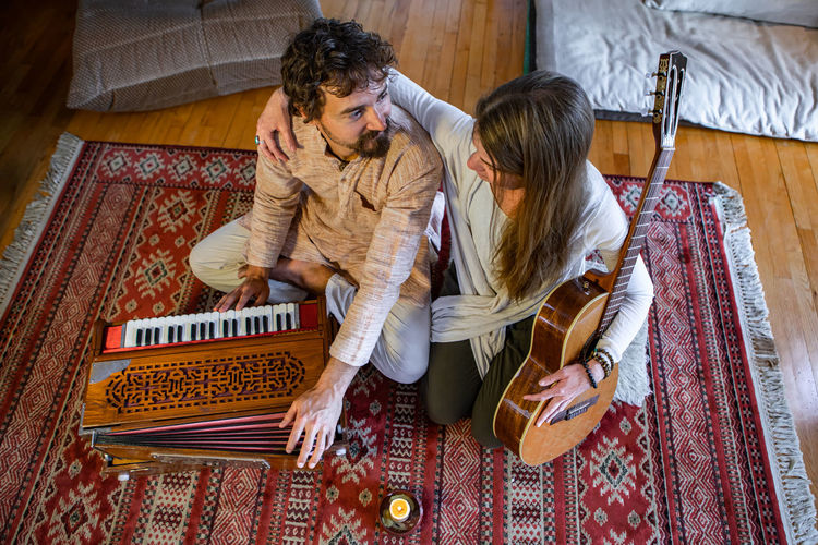 High angle view of couple sitting on floor at home