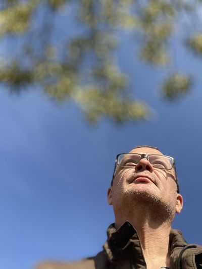 Low angle view of man looking up against sky