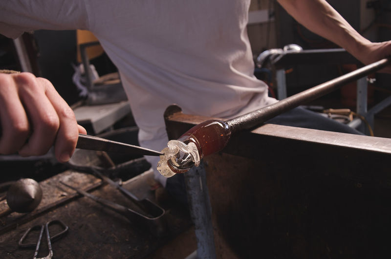 Close-up of man working in glass factory