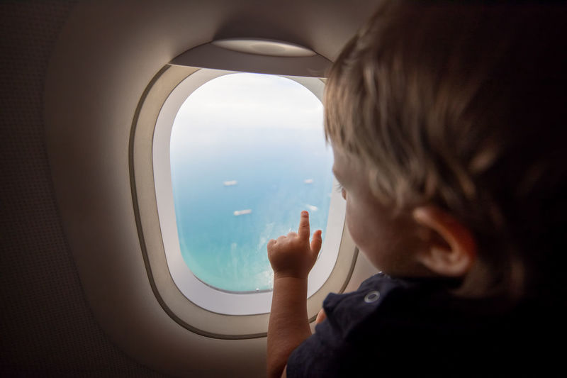 Boy looking through airplane window