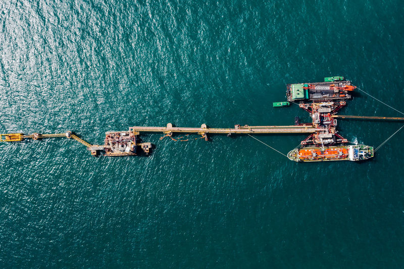 Oil ship tanker load and unloading oil at the oil station on the sea aerial photograph 
