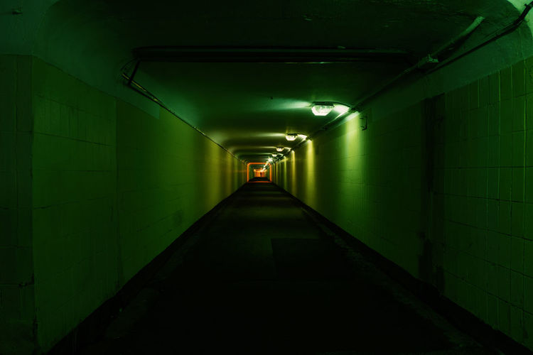 Empty corridor in illuminated tunnel