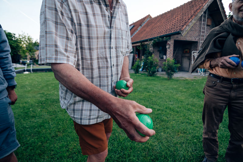 Close-up of elderly man's hands holding petanque bowls - leisure in the third age concept
