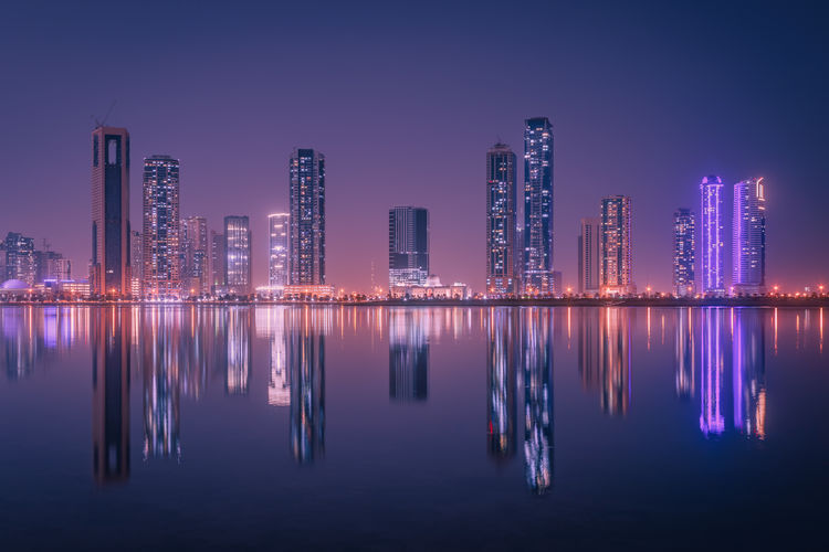 The tallest towers in the emirates and their reflection on the lakes at night, dubai, sharjah