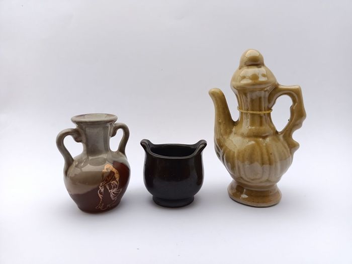 Three variations of isolated mini ceramic jug on white background