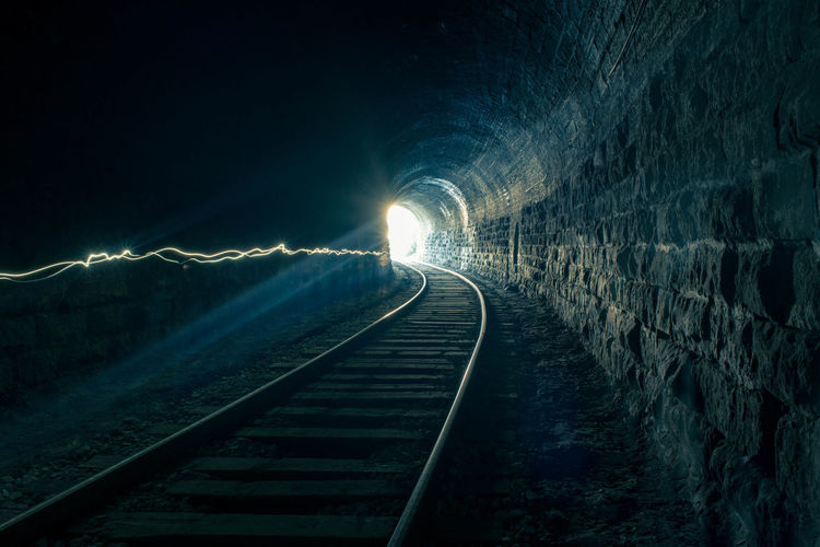 Light trails over railroad tracks in tunnel