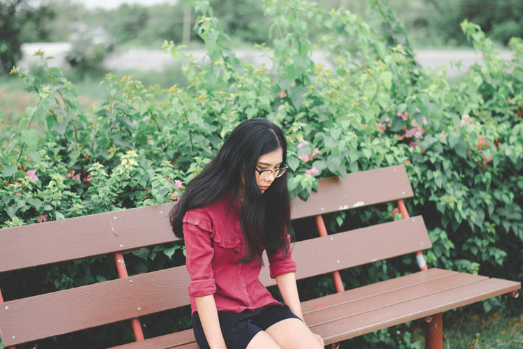 Young woman sitting on bench at park