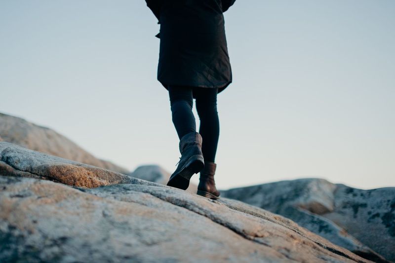 Low section of woman walking on rock