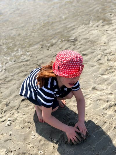 High angle view of girl playing with sand at beach