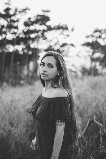 Portrait of young woman standing on field